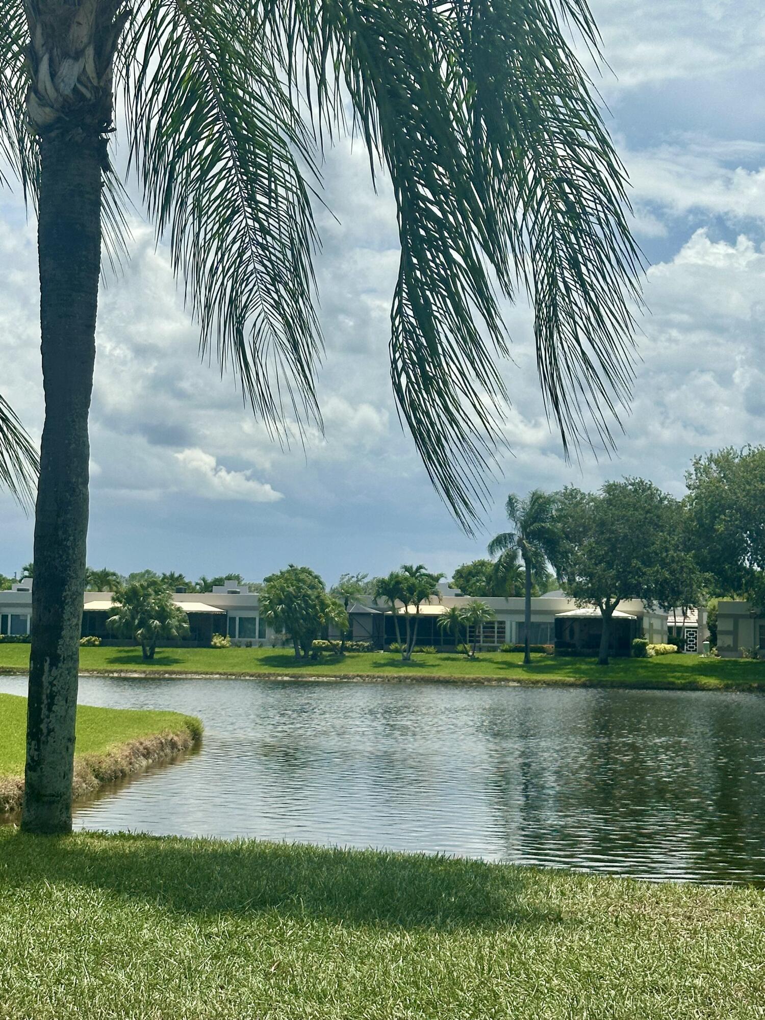 18900 Stewart Circle, Unit 7 Boca Raton, FL 33496 - Photo 22 of 23 a view of a lake with a big yard and large trees