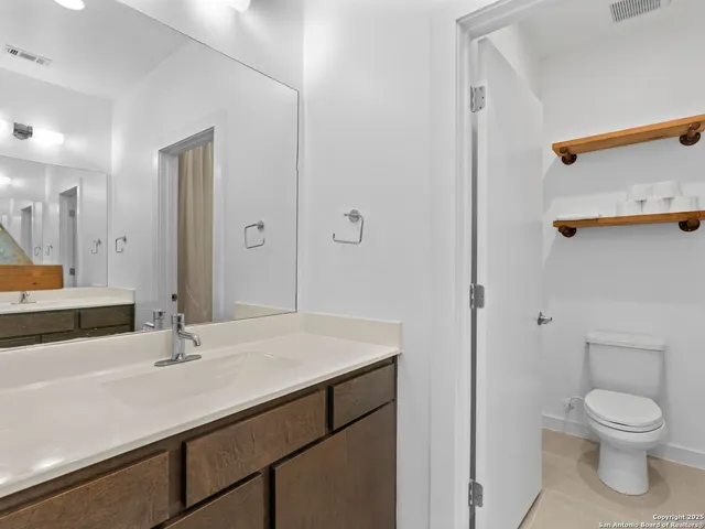 a bathroom with a sink a toilet and a mirror