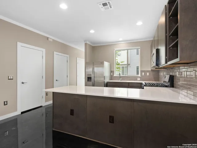 a view of a kitchen counter top space with stainless steel appliances granite countertop cabinets and a sink