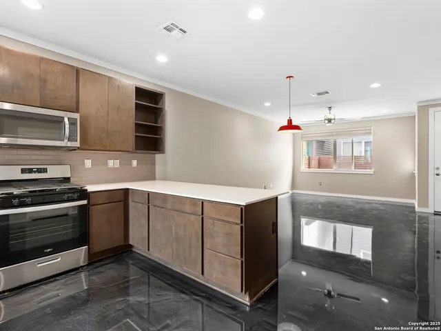 a kitchen with stainless steel appliances granite countertop a stove and a sink