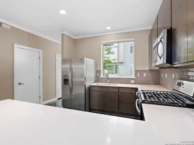 a kitchen with stainless steel appliances granite countertop a refrigerator sink and stove