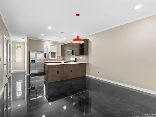 a kitchen with stainless steel appliances kitchen island granite countertop a sink cabinets and wooden floor