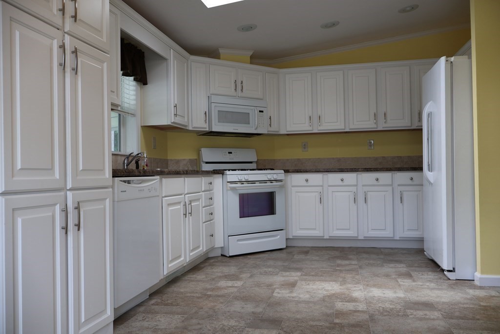 15 2nd Street Merrimac, MA 01860 - Photo 3 of 31 a kitchen with white cabinets and white appliances