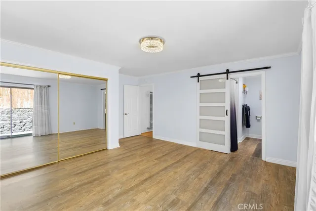 a view of empty room with wooden floor and window