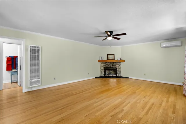 a view of a room with wooden floor and ceiling fan