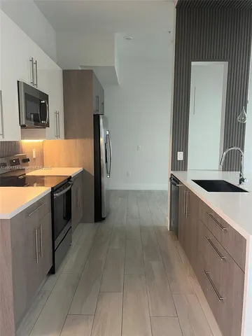 a large kitchen with a stove and a sink