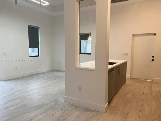 a view of a kitchen from the hallway with wooden floor