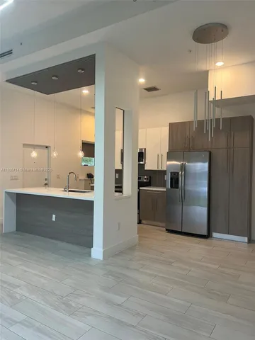 a kitchen with stainless steel appliances a refrigerator and a sink