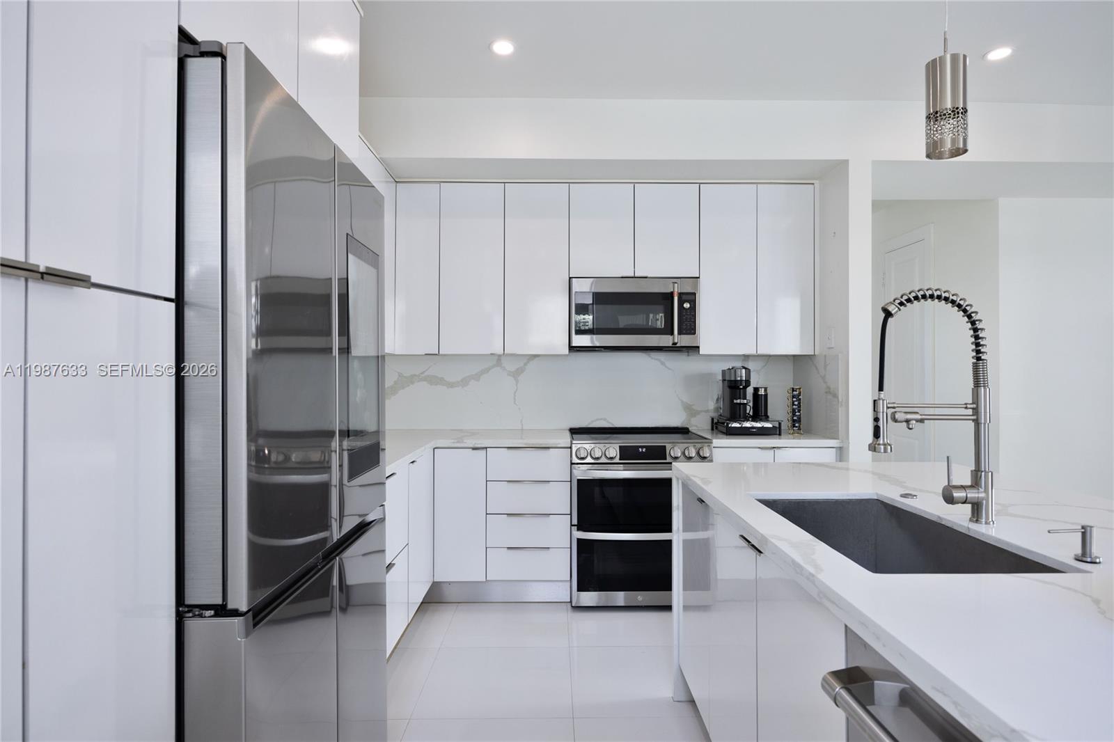 2981 Southwest 149th Avenue Miami, FL 33185 - Photo 12 of 30 a kitchen with a sink stainless steel appliances and cabinets