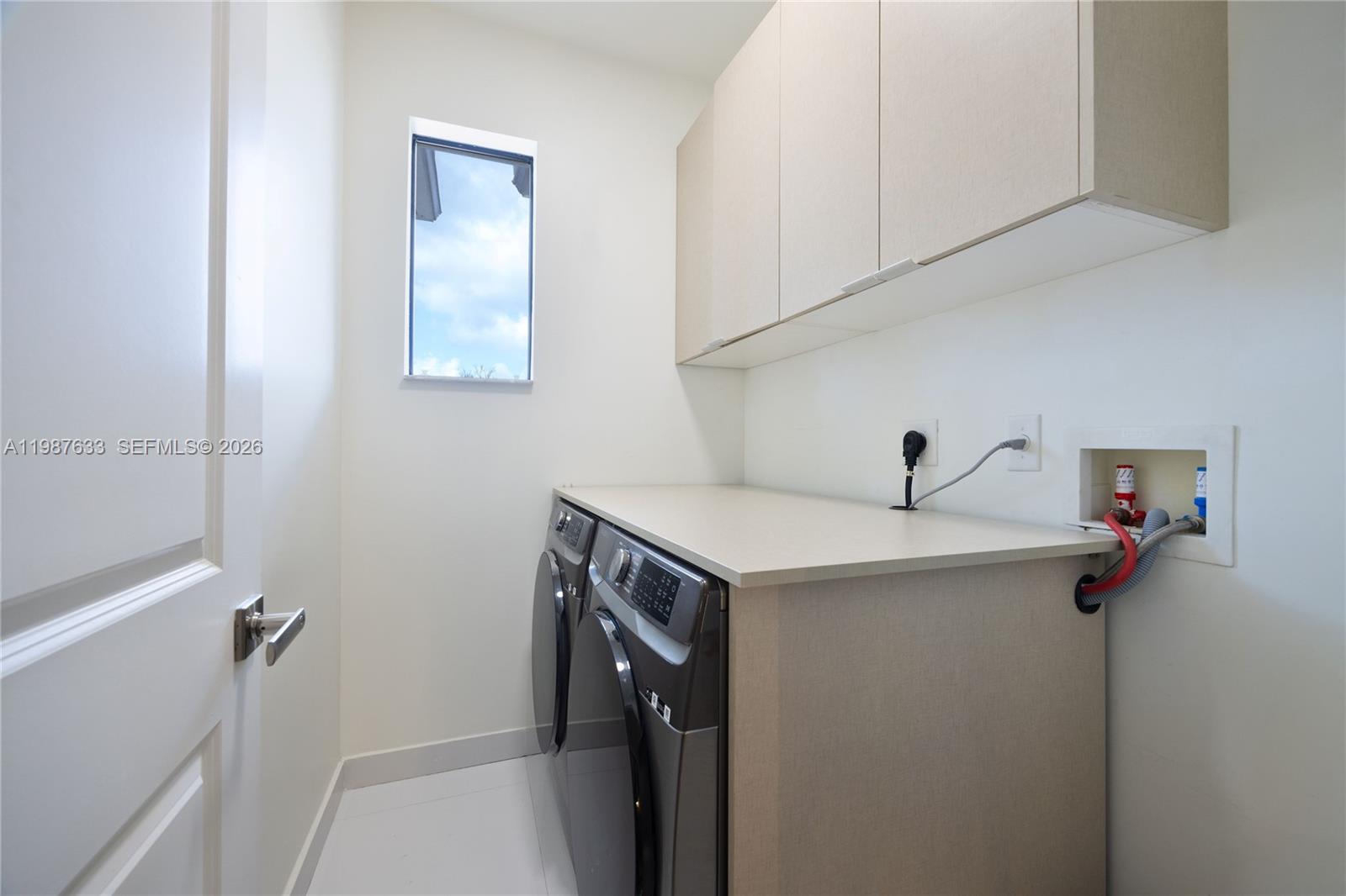 2981 Southwest 149th Avenue Miami, FL 33185 - Photo 22 of 30 a utility room with cabinets washer and dryer