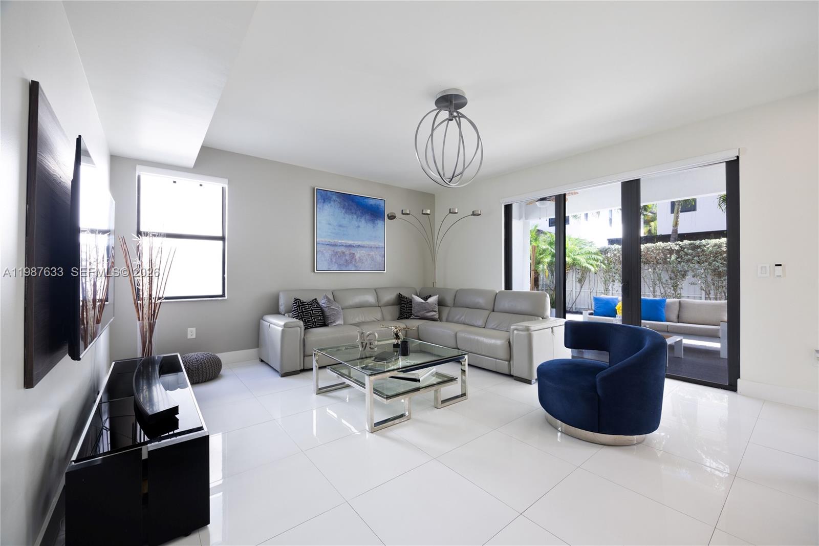 2981 Southwest 149th Avenue Miami, FL 33185 - Photo 8 of 30 a living room with furniture a chandelier and a flat screen tv