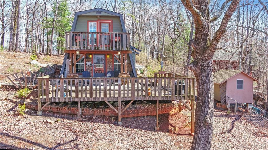 1492 Ivy Mountain Road Clarkesville, GA 30523 - Photo 37 of 53 a view of a wooden house with large trees and wooden fence