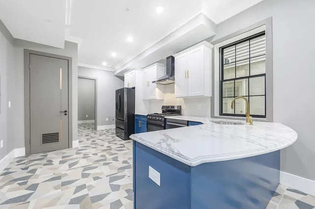 a kitchen with stainless steel appliances granite countertop a refrigerator and a sink