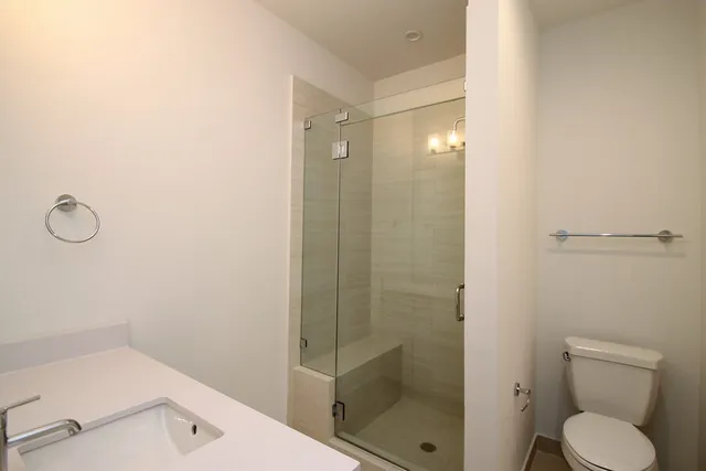 a bathroom with a shower a toilet and a sink