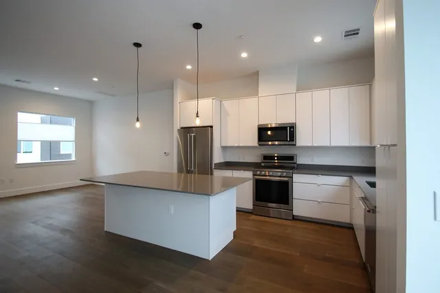 a kitchen with stainless steel appliances granite countertop a stove a sink and a refrigerator