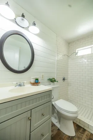 a bathroom with a granite countertop toilet a sink and mirror