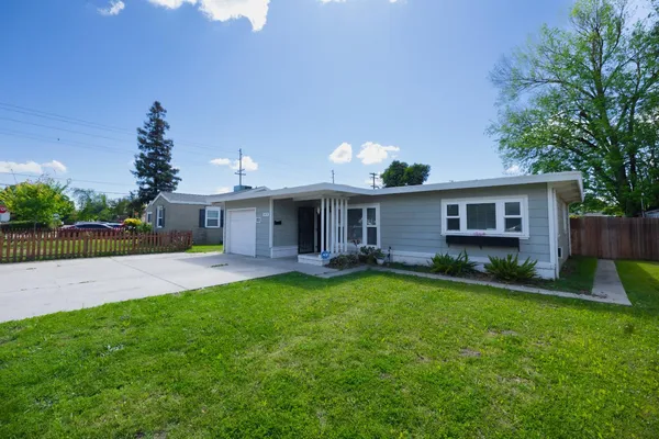 a view of a house with a yard and a patio