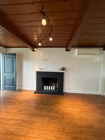 a view of an empty room with a fireplace and a window
