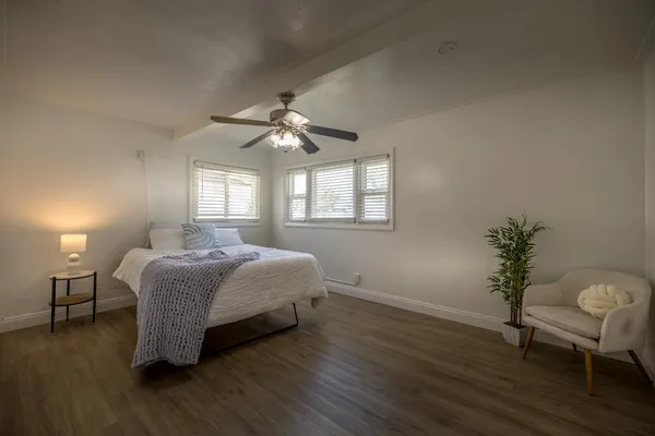 a spacious bedroom with a bed and a chair