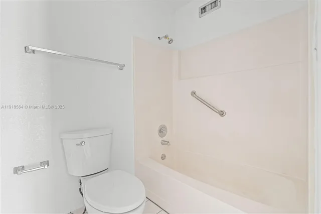 a white toilet sitting next to a bath tub