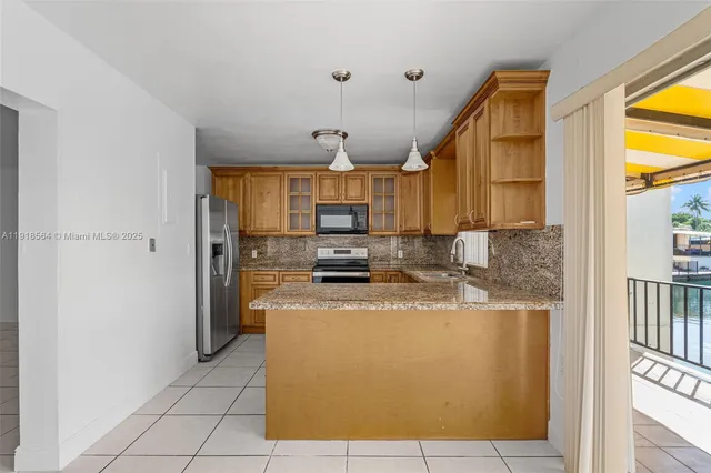 a kitchen with stainless steel appliances granite countertop a refrigerator a stove and a sink