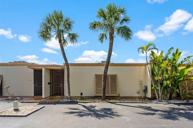 a couple of palm trees in front of a house