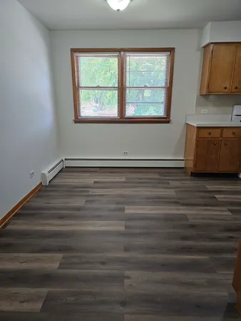 a view of a room with wooden floor and a window