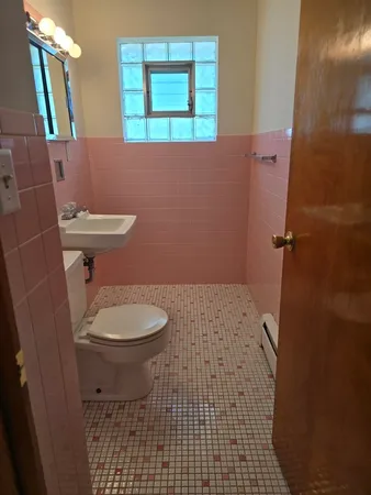 a bathroom with a toilet and a shower