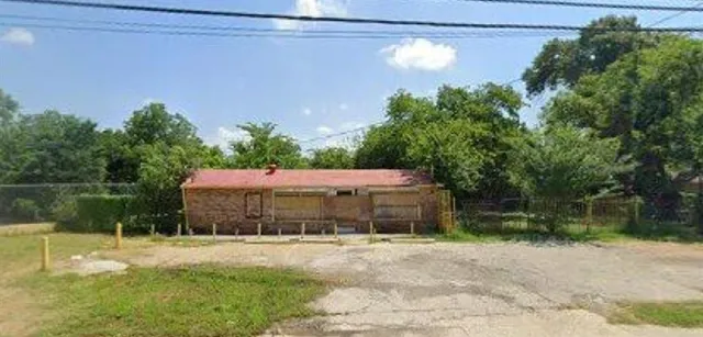 a view of a house with a yard and a large tree