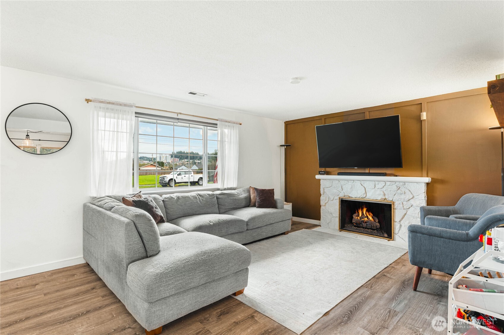 924 9th Street Southwest Puyallup, WA 98371 - Photo 9 of 38 a living room with furniture a fireplace and a flat screen tv