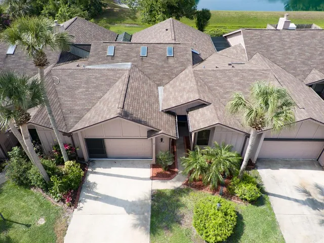 an aerial view of a house with a yard and large trees