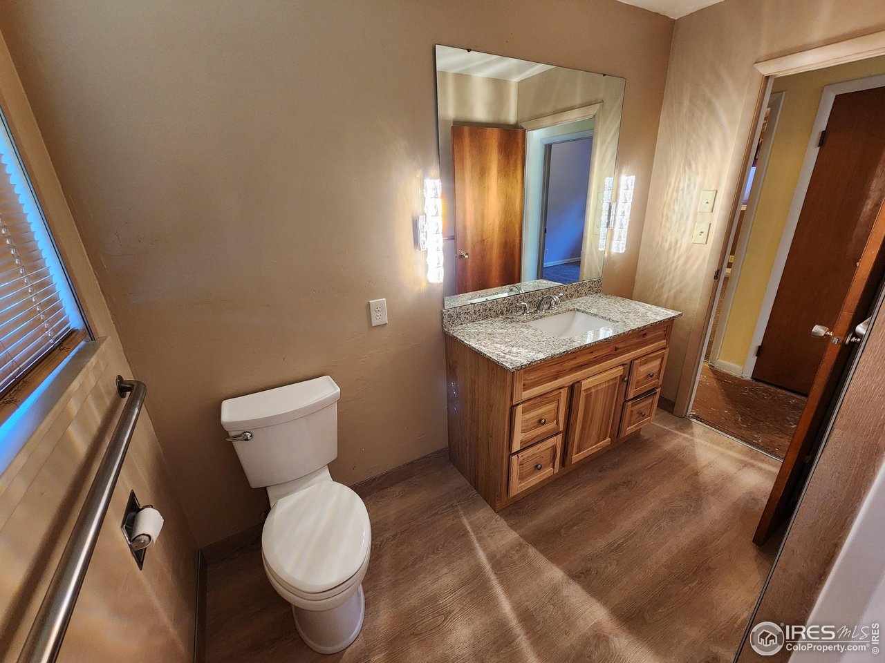 1107 Delmar Street Sterling, CO 80751 - Photo 16 of 49 a bathroom with a granite countertop toilet sink and mirror