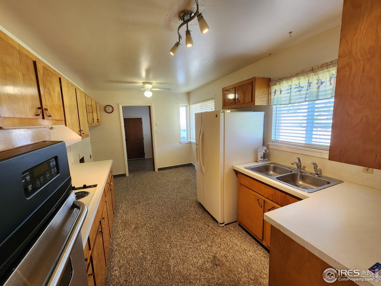 1107 Delmar Street Sterling, CO 80751 - Photo 17 of 49 a kitchen with stainless steel appliances granite countertop a sink a stove and a refrigerator