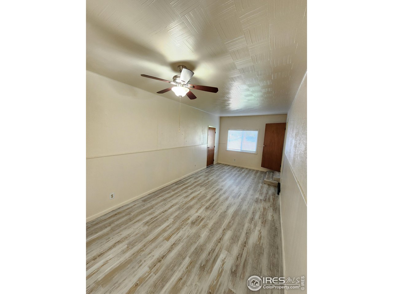 1107 Delmar Street Sterling, CO 80751 - Photo 24 of 49 a view of a room with wooden floor and ceiling fan