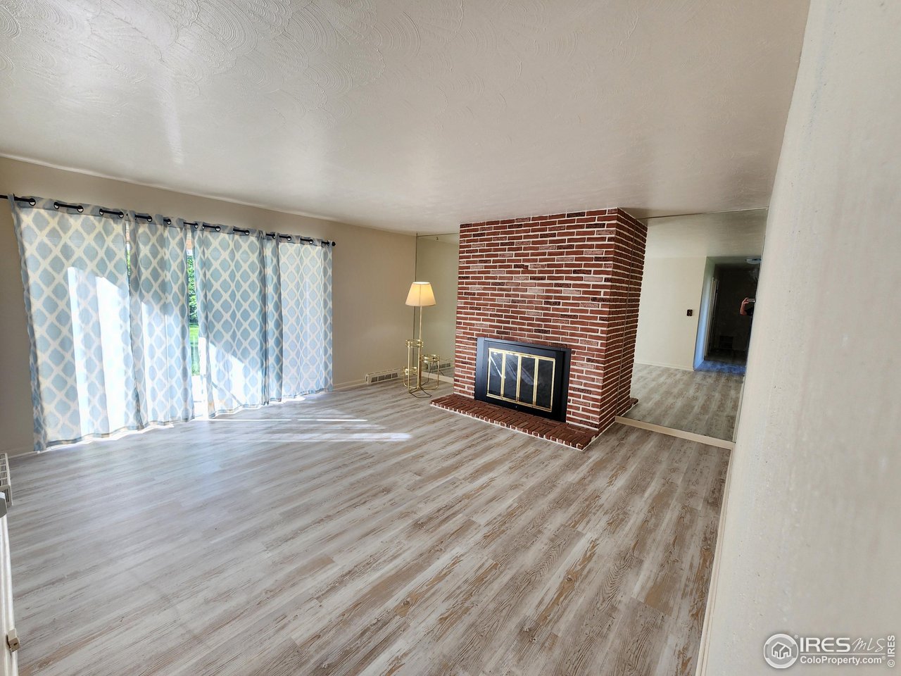 1107 Delmar Street Sterling, CO 80751 - Photo 3 of 49 a view of empty room with wooden floor and fireplace