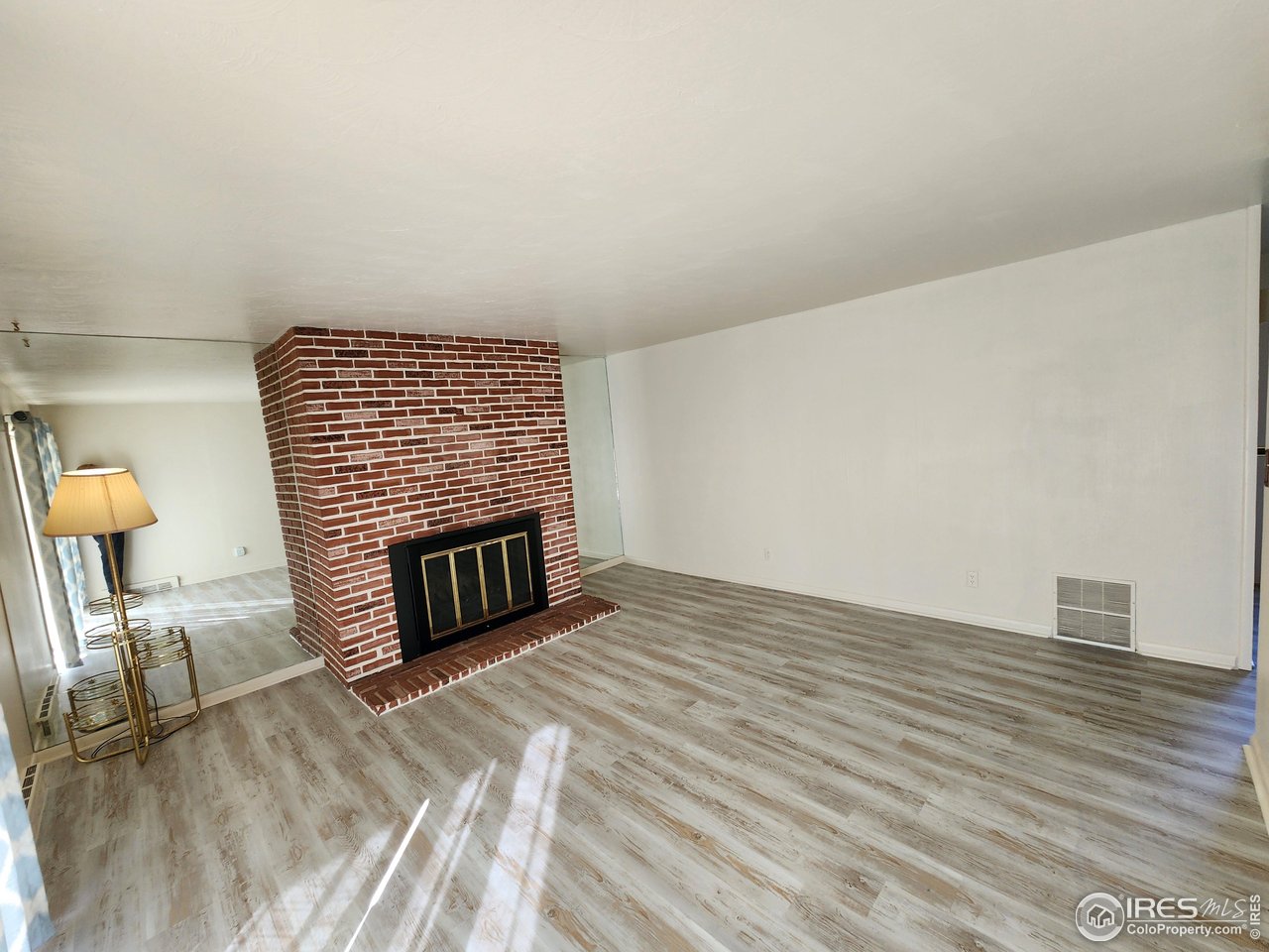 1107 Delmar Street Sterling, CO 80751 - Photo 4 of 49 a view of an empty room with wooden floor and a fireplace