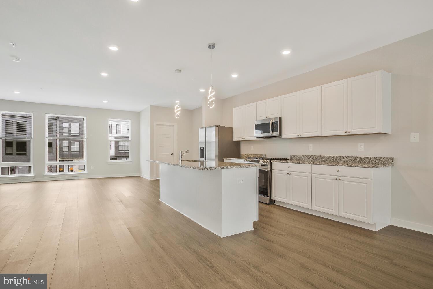 302 Summit Point Boulevard Bowie, MD 20716 - Photo 7 of 30 a large kitchen with stainless steel appliances granite countertop a large center island a sink a stove a refrigerator and cabinets