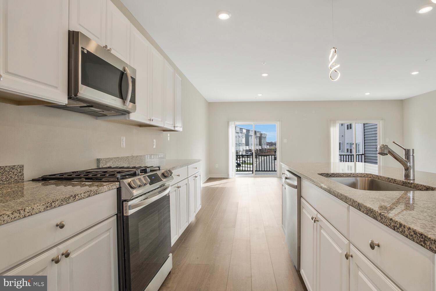 302 Summit Point Boulevard Bowie, MD 20716 - Photo 9 of 30 a kitchen with stainless steel appliances granite countertop a sink and stove top oven