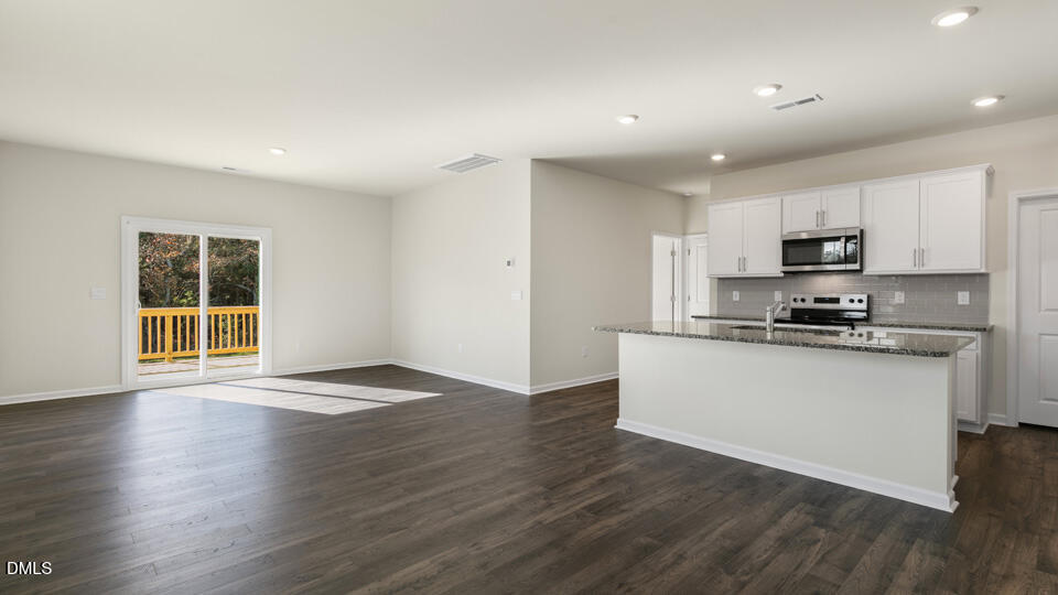 433 Hvn Hl Road Hillsborough, NC 27278 - Photo 8 of 33 a kitchen with granite countertop a stove top oven a sink a refrigerator and white cabinets with wooden floor