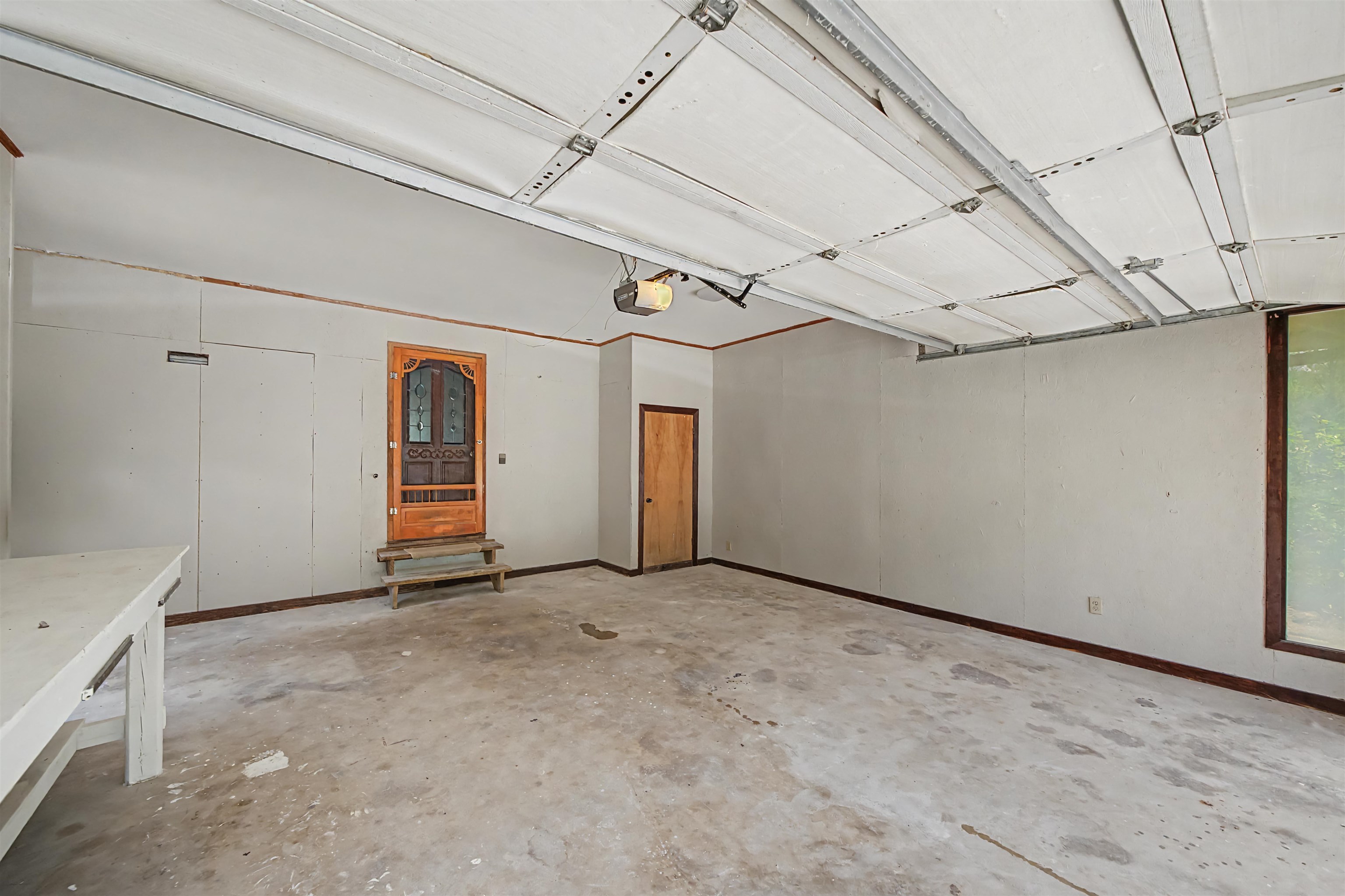 2380 Dunaway Road Selmer, TN 38375 - Photo 30 of 39 Spacious garage interior featuring an overhead garage door mechanism, concrete flooring, and multiple entry points