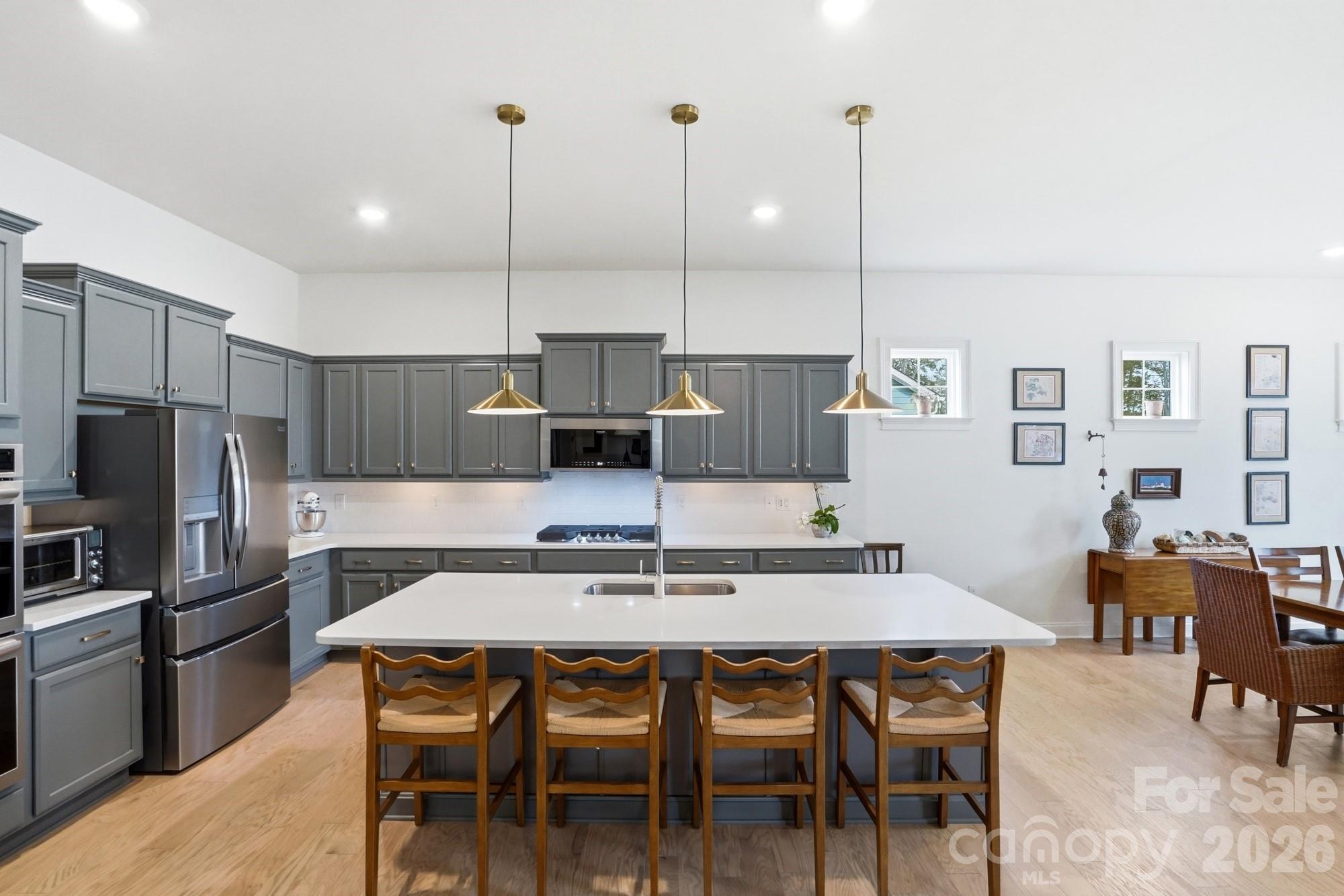 4012 Pollock View Mount Mount Holly, NC 28120 - Photo 11 of 48 a kitchen with a dining table chairs stainless steel appliances and cabinets