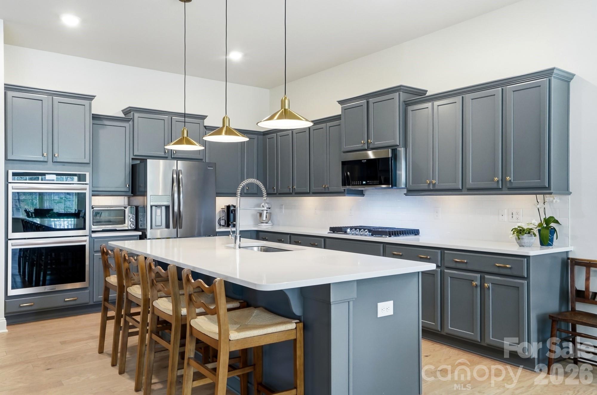 4012 Pollock View Mount Mount Holly, NC 28120 - Photo 13 of 48 a kitchen with stainless steel appliances a stove a sink a microwave a refrigerator and chairs