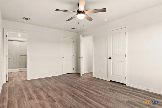 a view of empty room with wooden floor