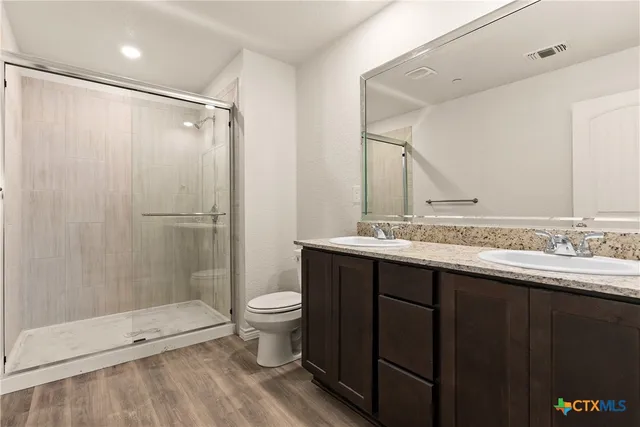 a bathroom with a shower sink vanity and toilet