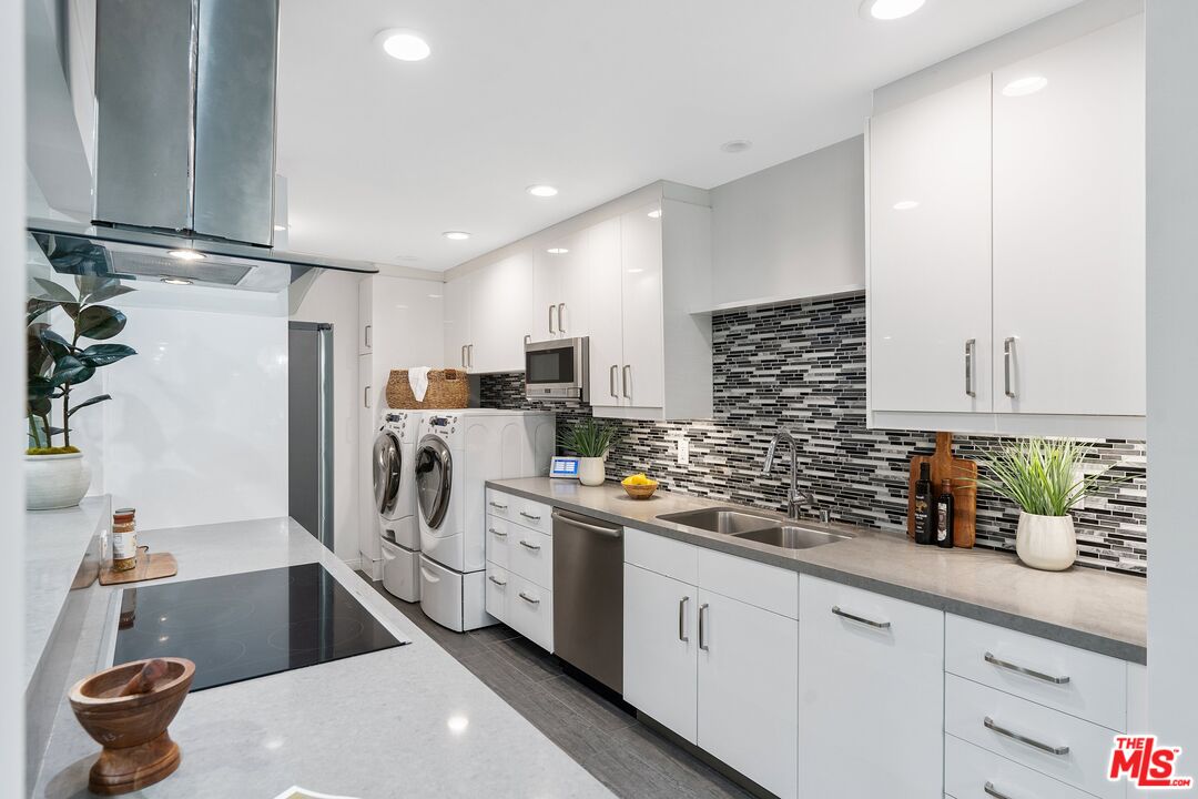 1015 North Kings Road, Unit 110 West Hollywood, CA 90069 - Photo 12 of 38 a kitchen with a sink stainless steel appliances and white cabinets