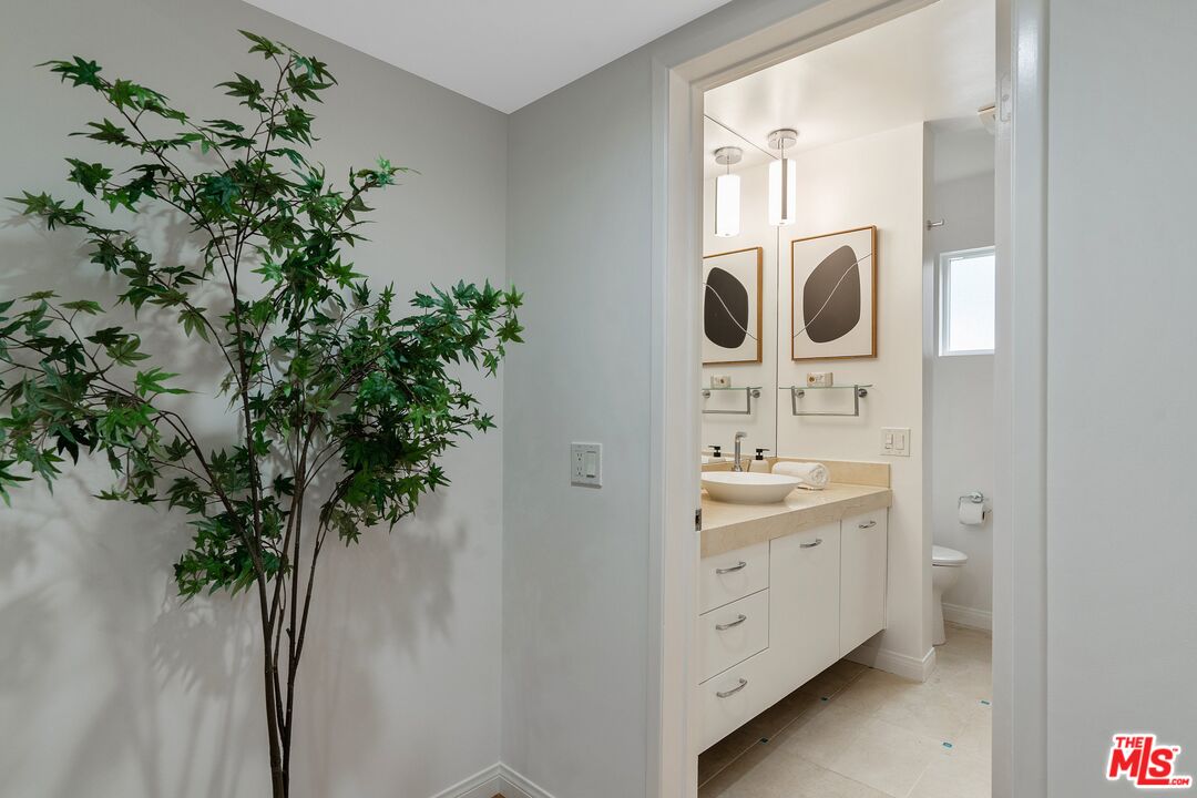 1015 North Kings Road, Unit 110 West Hollywood, CA 90069 - Photo 23 of 38 a bathroom with a sink and mirror