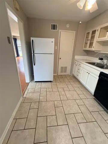 a kitchen with a sink a stove a refrigerator and cabinets