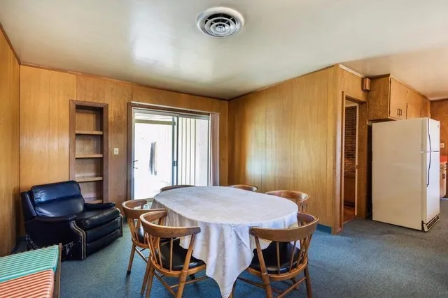 a view of a dining room with furniture and a chandelier