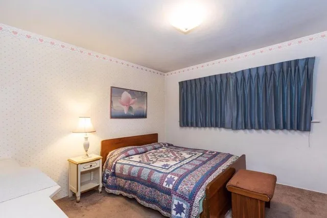 a bedroom with a bed and a lamp with wooden floor