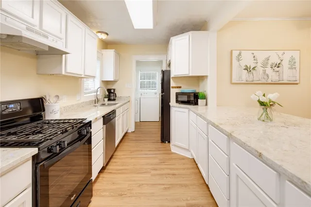 a kitchen with stainless steel appliances a sink stove top oven and cabinets